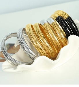 Detailed close-up of 12mm tri-color elastic steel bracelets on a white ceramic tray