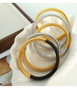 Detailed view of flexible snake bone bracelets in gold, silver, and two-tone finishes