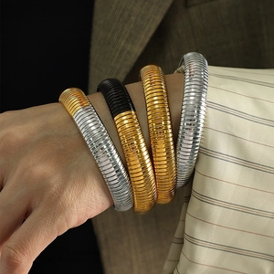 Stackable titanium steel spring bracelets in gold, silver, and two-tone mixed finishes