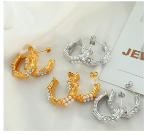 Detailed view of C-shaped hoop earrings with bamboo texture, pearls, and crystals in gold and silver