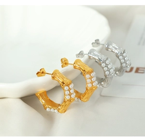 Detailed shot of C-shaped bamboo texture earrings with pearls in gold and silver finish