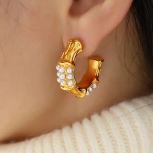 Retro C-shaped titanium steel bamboo-style hoop earrings with white pearls on a model