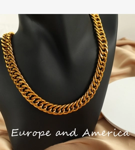 Dettaglio di una collana a maglia cubana dorata esposta su un manichino nero