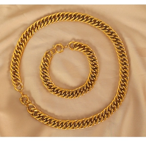 Dettaglio del set di catene a maglie cubane dorate con chiusura circolare su seta