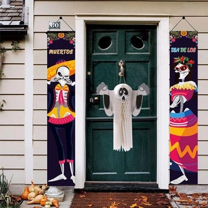 Outdoor entrance decorated with Dia de los Muertos banners and a white ghost ornament