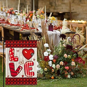 Macro detail of LOVE garden flag with buffalo plaid border on a metal bracket