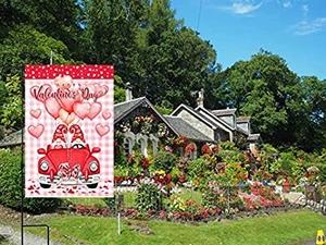 Close-up of double-sided Valentine's Day garden flag with gnomes in a vintage red car