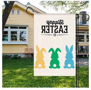 Easter garden flag with bunny silhouettes and Happy Easter text on green lawn