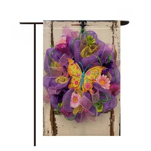 Close-up of a decorative garden flag featuring a colorful butterfly wreath on wood grain