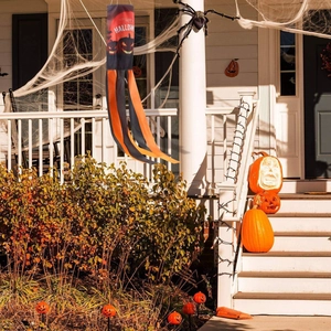 Halloween pumpkin windsock with Happy Halloween print hanging on an outdoor porch
