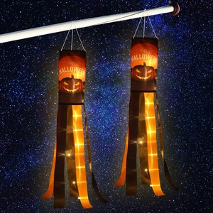 Detail of Halloween pumpkin windsocks with LED lights against a starry night sky