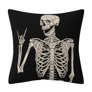 Detail of black linen pillow cover featuring a cream skull with a rock hand gesture print