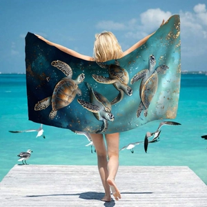 Microfiber beach towel with sea turtle print held by a model on a sunny seaside pier