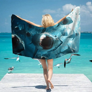 Microfiber beach towel with deep sea shark print held by model on a sunny wooden pier