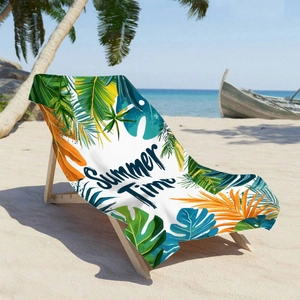 Microfiber beach towel with tropical leaves and Summer Time print on a sunny beach
