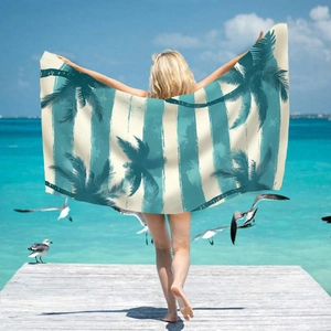 Microfiber beach towel detail with turquoise palm tree print on striped quick-dry fabric