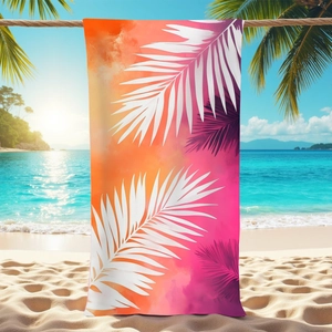 Tropical palm leaf microfiber beach towel with orange gradient hanging on a sunny beach