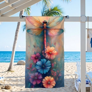 Microfiber beach towel featuring a colorful dragonfly and floral print on a sunny beach