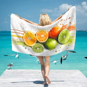 Microfiber beach towel with citrus fruit print held by a model on a sunny pier beach