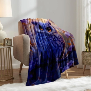 Detail of artistic purple owl print on soft flannel blanket draped over a cozy sofa