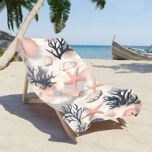Microfiber beach towel with pink seashells and blue coral design on a wooden beach chair