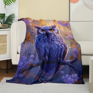 Purple owl flannel blanket with digital floral print draped on a beige sofa in a cozy home