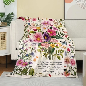Close-up of flannel blanket with floral and butterfly prints on a light fabric sofa