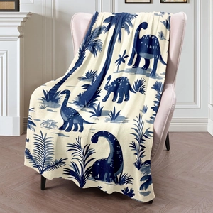 Cozy flannel blanket with blue dinosaur and palm tree print on soft cream fabric