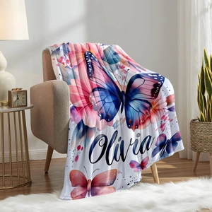 Custom flannel blanket with blue butterfly and floral patterns on a cozy beige armchair