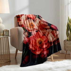 Floral flannel blanket with large red peonies draped on a sofa in a cozy home setting