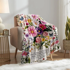 Floral flannel throw blanket with butterfly prints draped over a cozy armchair