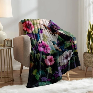 Flannel blanket with vibrant hummingbird and floral digital print on a beige sofa