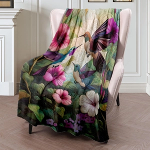 Flannel hummingbird floral blanket draped on a cozy sofa in a warm living room