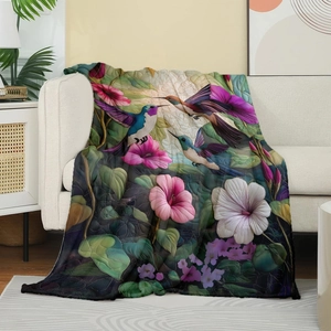 Detail of hummingbird and floral print on soft flannel throw blanket over a sofa