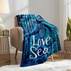 Blue flannel throw blanket with ocean sea turtle print and Love Sea text on sofa