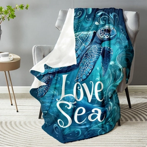 Navy blue sea turtle flannel blanket with Love Sea print draped on a cozy sofa