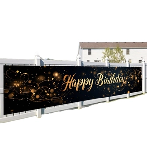 Luxurious black and gold Happy Birthday banner displayed on a white garden fence