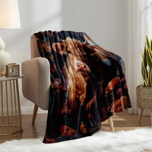 Detail of soft flannel blanket featuring a Highland cow with floral patterns on a sofa