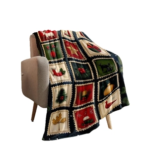 Christmas flannel blanket featuring vintage stamp patterns with deer and trees on a sofa