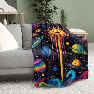 Soft flannel blanket with cartoon universe space pattern draped over a modern grey sofa