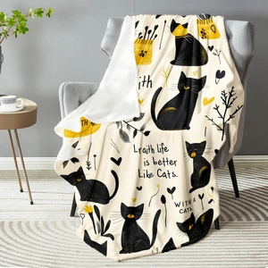 Cozy flannel blanket with cartoon cat print and sherpa backing on a grey sofa