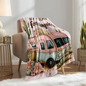 Bohemian flannel fleece blanket with retro camper and floral print on a cozy sofa