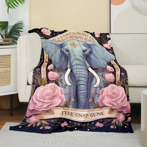 Detail of soft elephant flannel blanket with pink roses draped on a white sofa