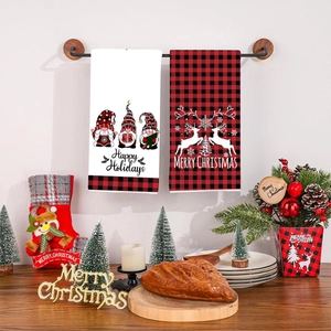 Set of two Christmas hand towels with gnome and reindeer patterns in kitchen setting