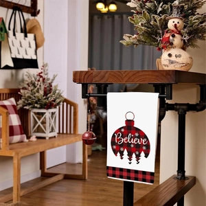 Detail of Christmas hand towel with Believe red buffalo plaid ornament design and forest motif