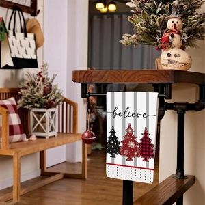 Detail view of a striped Christmas towel with tree patterns and believe text on a wooden rack
