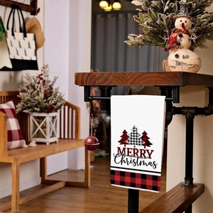 Asciugamano di Natale con alberi a quadri e scritta Merry Christmas su sfondo rustico