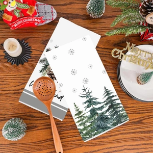 Christmas hand towel set with festive tree and snowflake print on wooden table