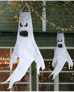 Detailansicht weißer Halloween-Geist-Windsäcke mit gruseligen Gesichtern an Baumzweigen