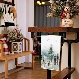 Detail of Christmas hand towel featuring reindeer and pine tree watercolor patterns